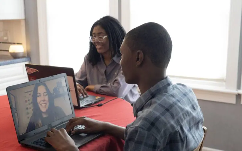 Two students attending to an online class together at home
